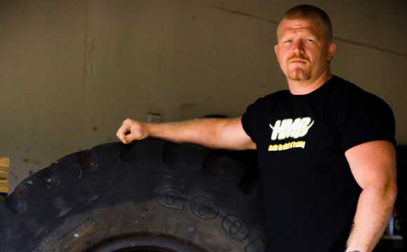 Strongman athlete Eric Todd posing with tire implement