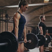 female and male athlete deadlifting during CrossFit workout