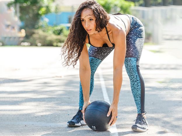 health and wellness coach Jada Kelly exercising with medicine ball