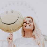 woman smiling with a happy face balloon / myhmb blog ways to improve your mood by Jennifer Dietrick