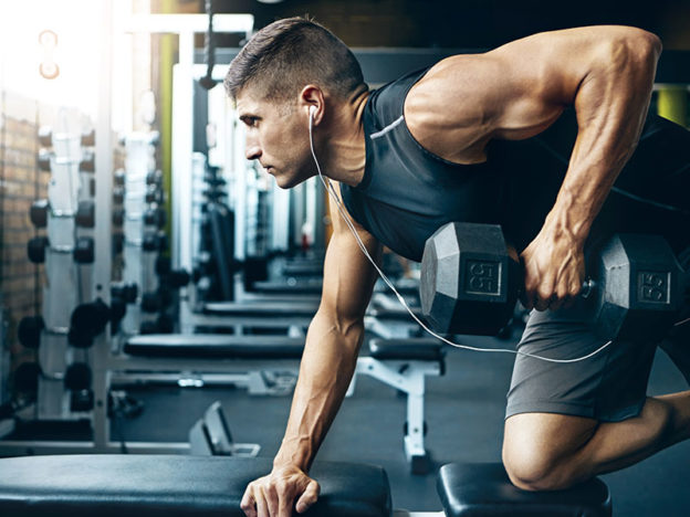 Male athlete performing bent over row at the gym