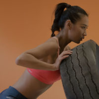 Building Strong Women / Your Body / myHMB Blog / Woman fliping a tire