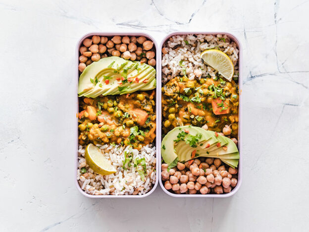 two dishes of a chicken burrito bowl with rice, beans, avocado, and rice