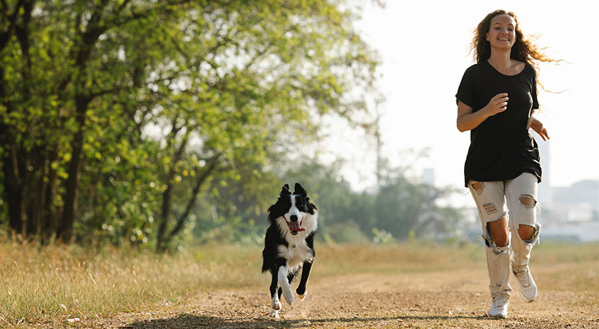 girl in nature running with her dog | healthy active habits