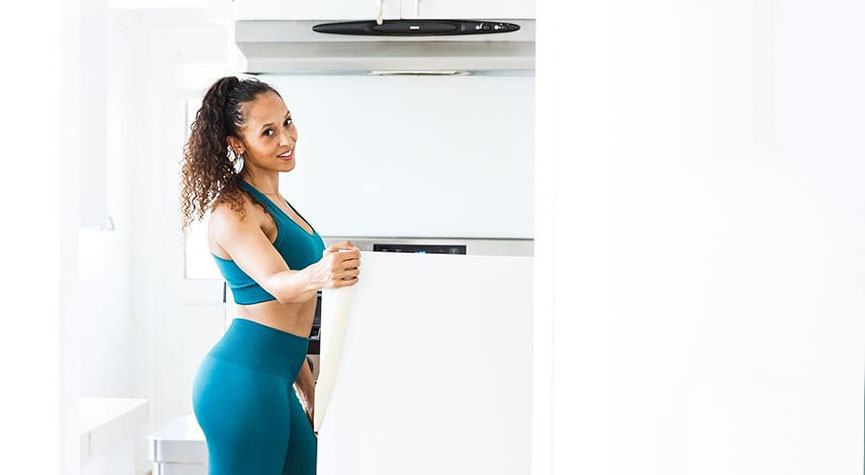 personal trainer, team myhmb athlete, and nutrition coach Jada Kelly in a kitchen looking into a fridge