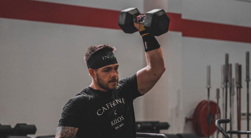 team myHMB athlete and CrossFit athlete Rob Schillaci in a gym doing a dumbbell snatch