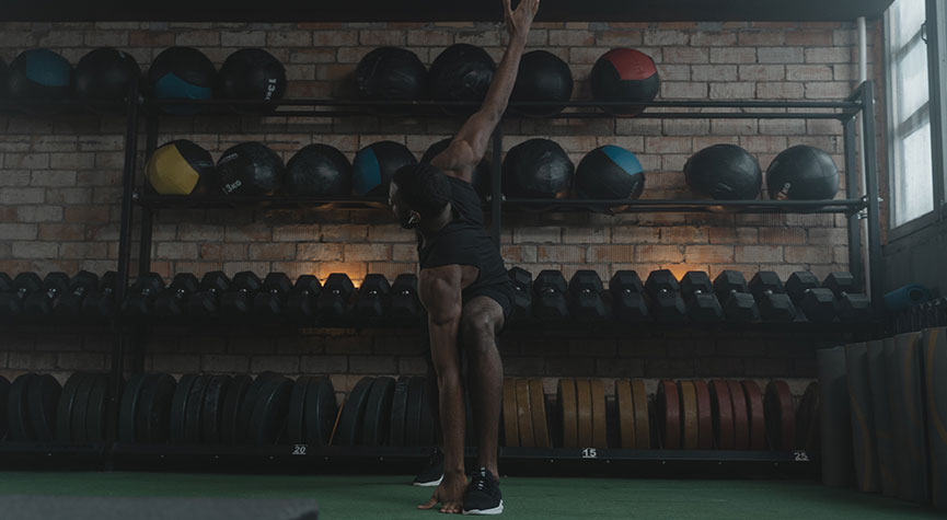 athletic man in a crossfit gym performing the ultimate stretch