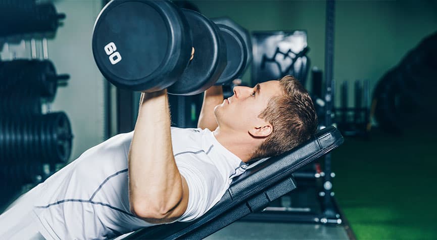 athletic male performing incline bench with 60 lb. dumbbells / myHMB blog Why You Aren’t Seeing Results from Your Workouts (Part 1)