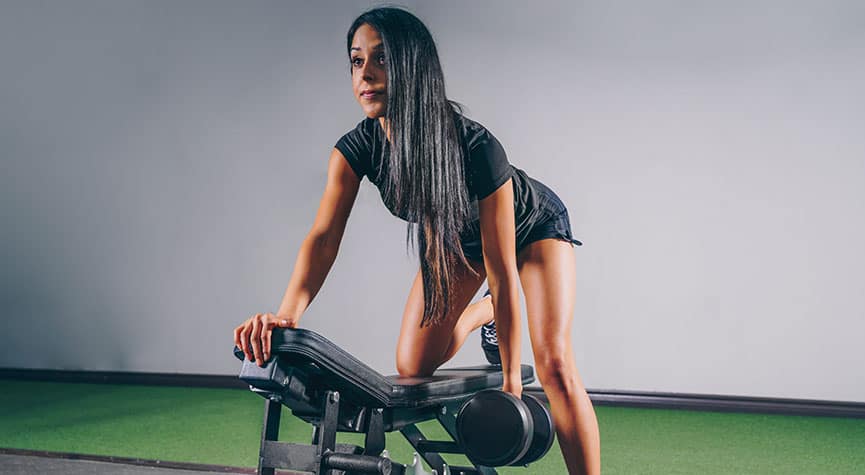 woman in a gym doing a bent over row with a dumbbell / myHMB blog Why You Aren’t Seeing Results from Your Workouts (Part 1)
