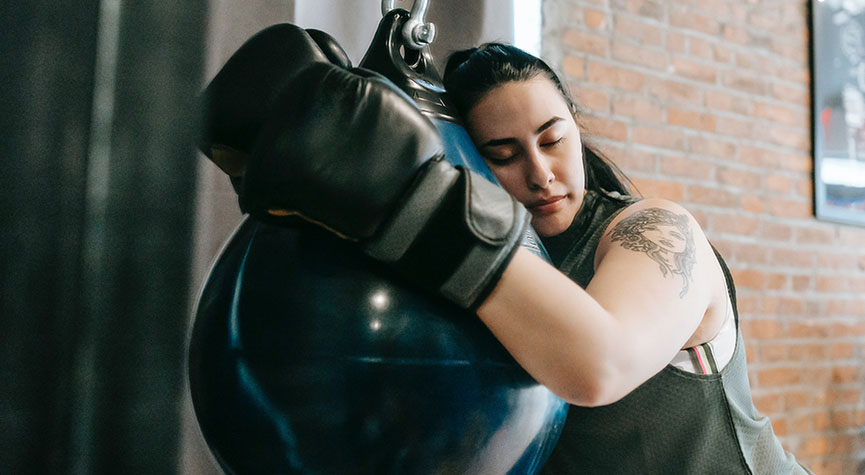 woman hugging and sleeping on a boxing bag / myHMB blog 4 Principles to a Balanced, Healthy Lifestyle