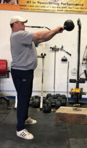 Hall of Fame powerlifter Brad Gillngham at Jackals gym performing kettlebell swings