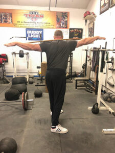 Hall of Fame powerlifter Brad Gillngham at Jackals gym performing Standing Trunk (Oblique) Twist