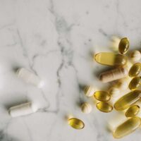 marble table top with a mixture of different dietary supplement tablets and capsules \ myHMB Blog A Guide to Choosing Supplements Wisely